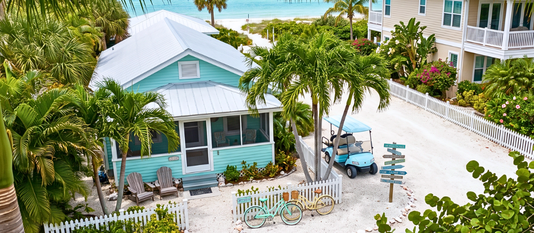 Old Florida beach homes and a golf cart reflect Anna Maria Island timeless coastal charm.